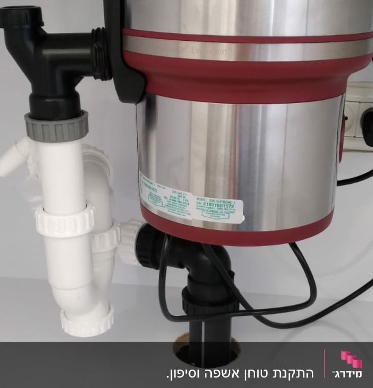 מכשיר טוחן אשפה מתחת לכיור עם צינורות חיבור